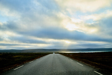 Landscape with road in tundra in Norway at cloudy evening