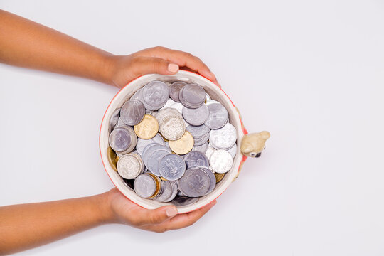 Child's Hands Holding Money In A Clay Pot, Concept Of Donation, Saving, Charity, Family Finance Plan, Collection For Coronavirus Or Covid-19 Pandemic Economic And Rescue Package Concept.