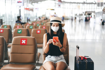 Young adult tourist woman wear mask for virus outbreak at airport terminal with social distancing chair. - obrazy, fototapety, plakaty