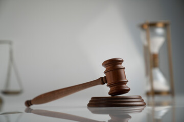 Law and justice concept. Scale, gavel and hourglass on off-white background.