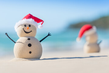 Two Sandy Christmas Snowmen are celebrating Christmas on a beautiful beach, one of them is out of  focus and only shows it's back