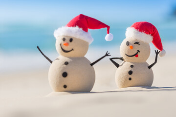 Two Sandy Christmas Snowmen are celebrating Christmas on a beautiful beach, one of them is only in focus