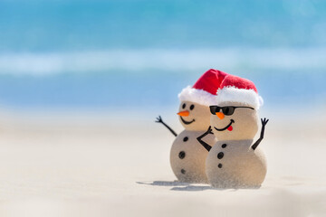 Two Sandy Christmas Snowmen are celebrating Christmas on a beautiful beach, one of them is only in focus and wearing sunglasses © fogaas