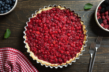 Open pie from shortcrust pastry with cherries, cherry clafoutis on wooden background