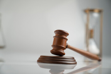Law and justice concept. Scale, gavel and hourglass on off-white background.