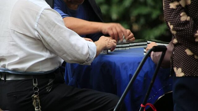 Senior men playing mah jong at park