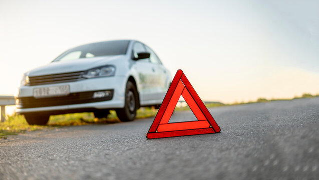 red triangle sign on the road as the symbol of the car crash accident on highway