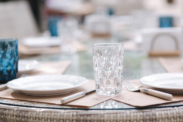 Close up of Served table set at suumer terrace. Cutlery in cafe. Blue glasses