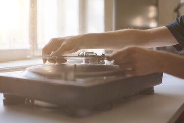 close up person's hand put the needle on a record, playing vinyl disc at the party
