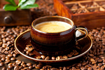 Obraz na płótnie Canvas Coffee cup and coffee beans on dark background