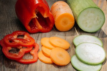 Carrots, red peppers and zucchini on a wooden table. Dietary food. Vegetables.