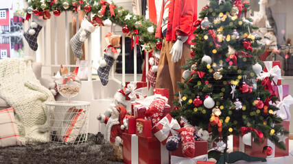 Gift boxes under Christmas tree, New Year home decorations, red wrapping Santa presents, fir tree decorated, beautiful bokeh of garland.
