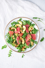 Fresh salad with arugula, avocado and grapefruit