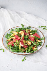 Fresh salad with arugula, avocado and grapefruit