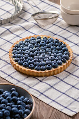 Blueberry tart with fresh berries on wooden background