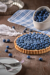 Fototapeta na wymiar Blueberry tart with fresh berries on wooden background