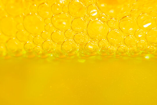 Blurred abstract light yellow background with bubbles. The concept is summer, soft drinks, freshness. For the backing of a site or mobile application.