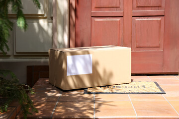 Fototapeta na wymiar Delivered parcel on door mat near entrance