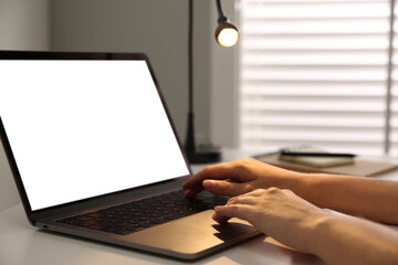 Woman working with modern laptop at white table, closeup