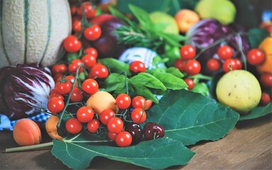 closeup of a bunch of cherry tomatoes and other fruits and vegetables - natural and healthy food concept