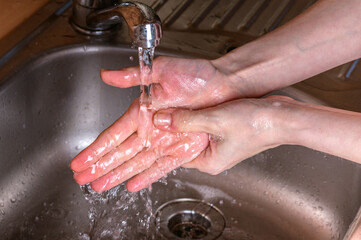 Fototapeta premium Woman use soap and washing hands under the water tap