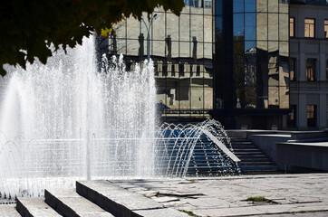 City fountain in the background of a building with a glass facade