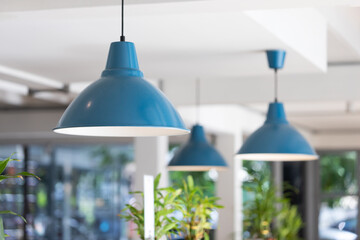 blue metal lamp hanging from white ceiling in living room.  blue steel lamp decoration.