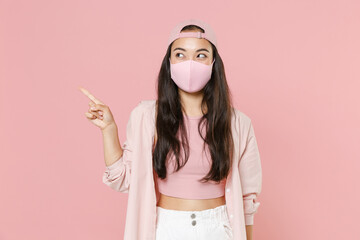 Young asian woman girl in casual clothes cap face mask posing isolated on pastel pink background....
