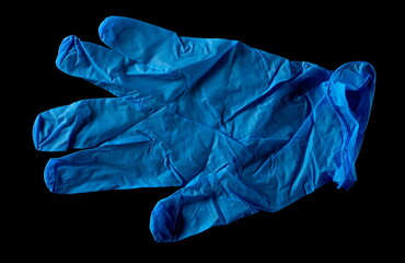 Blue surgical latex glove isolated on black background, top view