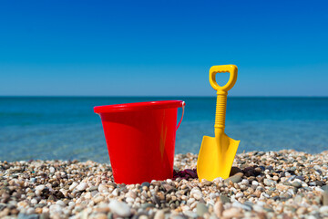 Toy bucket and spade on the beach stones