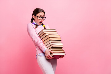Profile photo of overloaded pretty student girl lady hold heavy books pile prepare examination college big homework library carry tired wear shirt specs pants isolated pink color background