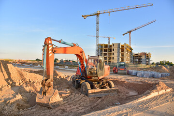 Excavator during road work at construction site. Screeding gravel for laying asphalt and installing...