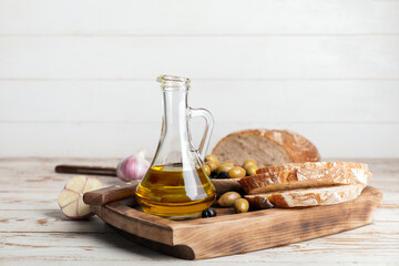 Obraz na płótnie Canvas Bottle of tasty olive oil and bread on table