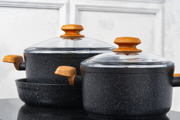 Black cookware on induction stove against grey wall