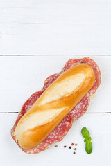 Sub sandwich baguette with salami portrait format copyspace copy space from above on wooden board