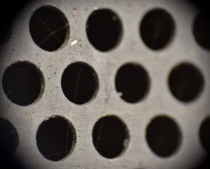 Black sheet metal background with holes.
