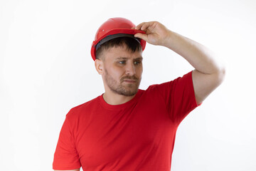 A man in a construction helmet and a red T-shirt.