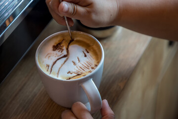 Barista hand design paint draw cappuccino. 