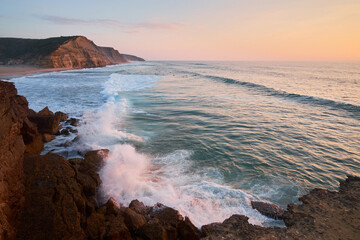 Wide shot of the São Julião Beach in Ericeira Portugal at sunset.