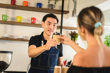 Barista giving bag and paper cups with hot drinks to customer at coffee shop