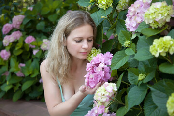 
Beautiful girl in the garden of blooming hydrangea