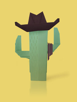 A cactus cawboy western in a brown hat and lasso on yellow