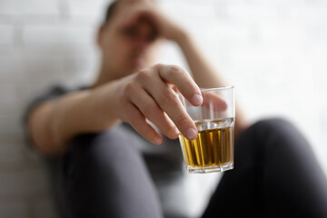 man suffering from alcoholism, close up of whiskey glass in male hand
