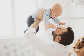 Fototapeta premium Happy father holding little baby son. Fatherhood concept