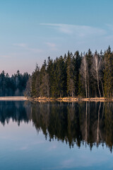 reflection of trees in the lake with blue sky