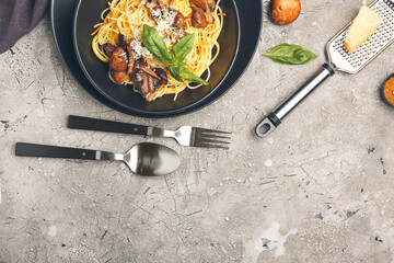 Plate with tasty pasta and mushrooms on grey background
