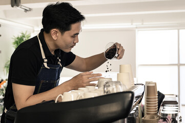 The young barista is determined to make coffee meticulously.