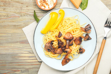 Plate with tasty pasta and mushrooms on table