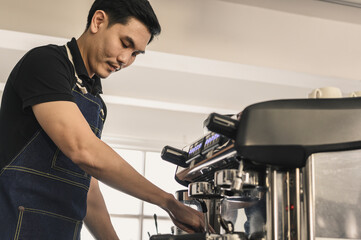The young barista is determined to make coffee meticulously.