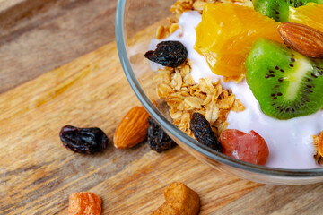 Bowl of granola with youghurt and sliced fruits